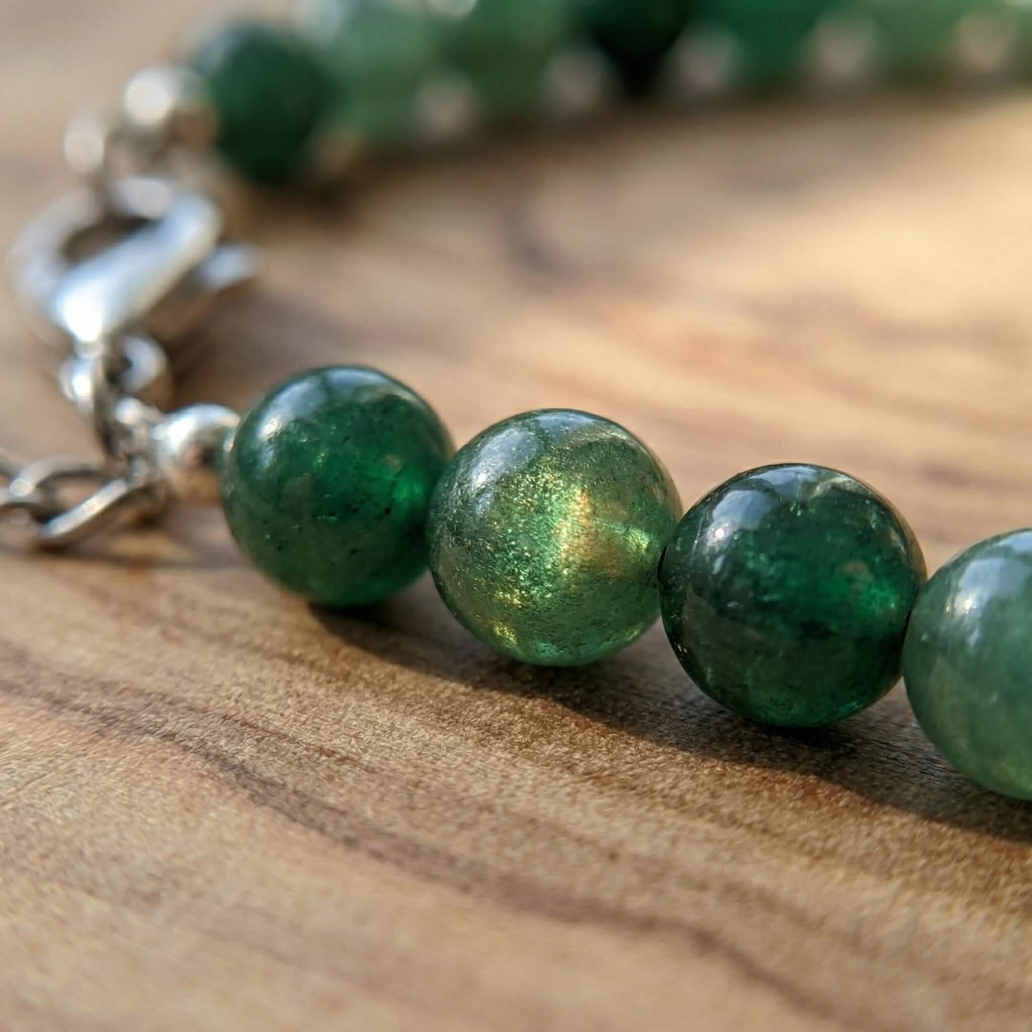 Macro close-up of green aventurine beads on Sunavyaa anklet showing natural aventurescent shimmer