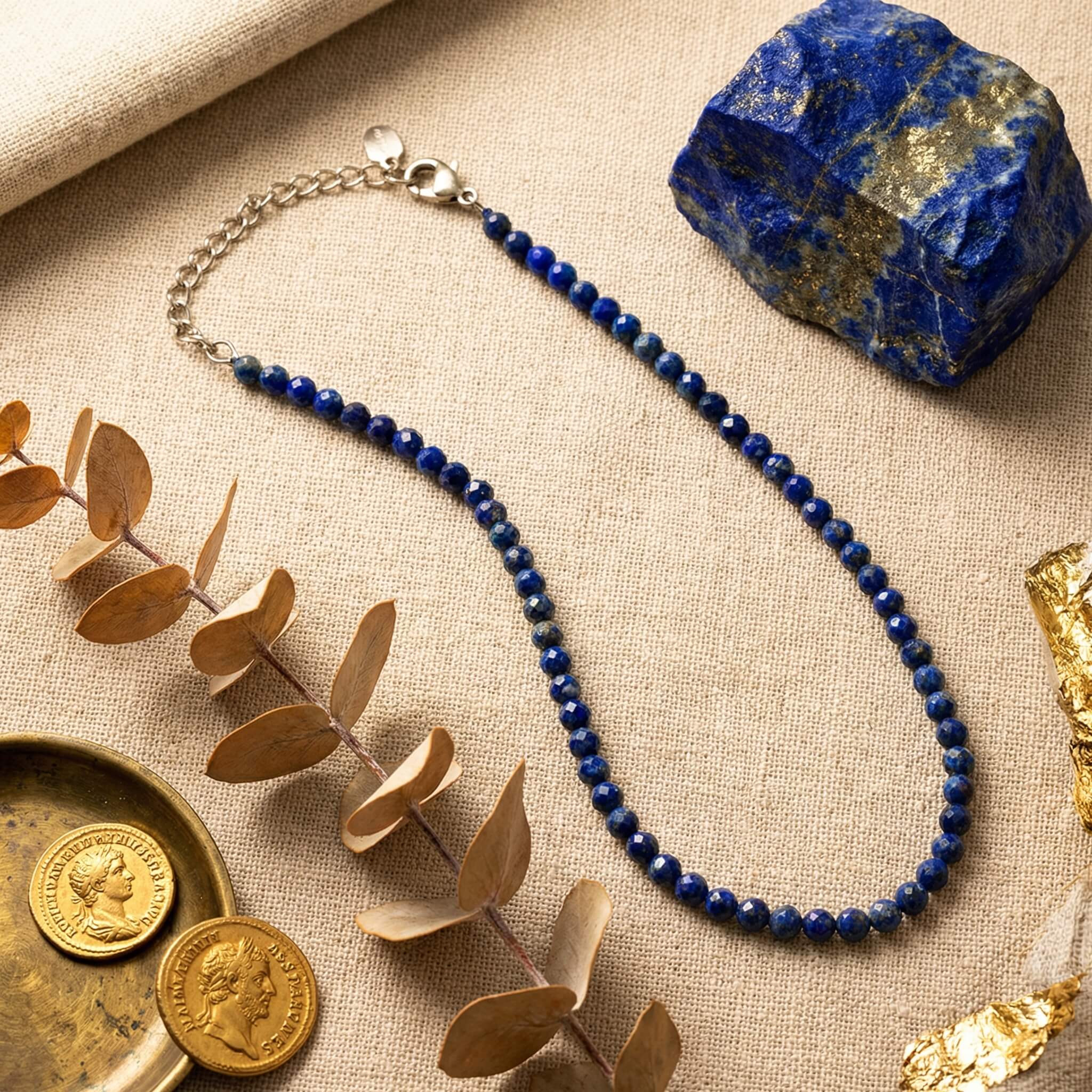 Sunavyaa lapis lazuli crystal anklet on dark navy marble with raw lapis stone and blue thistle