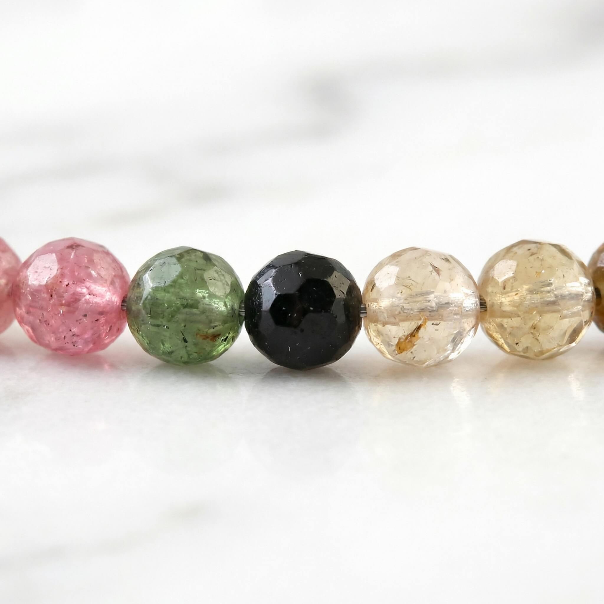 Macro close-up of pink green and blue tourmaline beads on Sunavyaa anklet showing colour contrast
