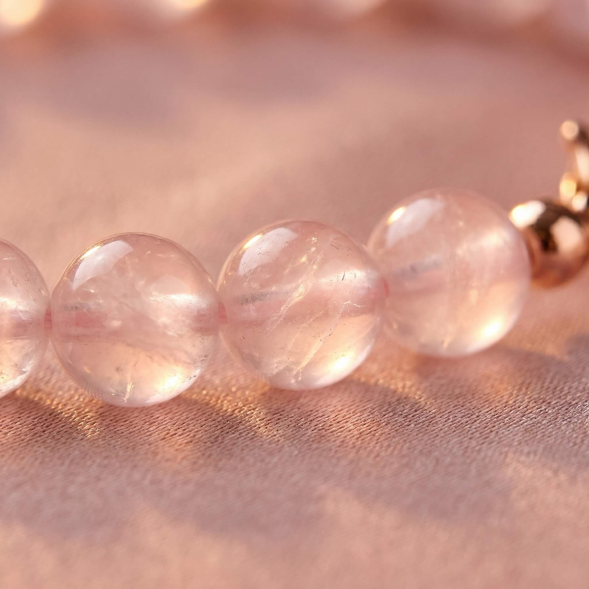 Macro close-up of milky pink rose quartz beads on Sunavyaa anklet showing translucent glow
